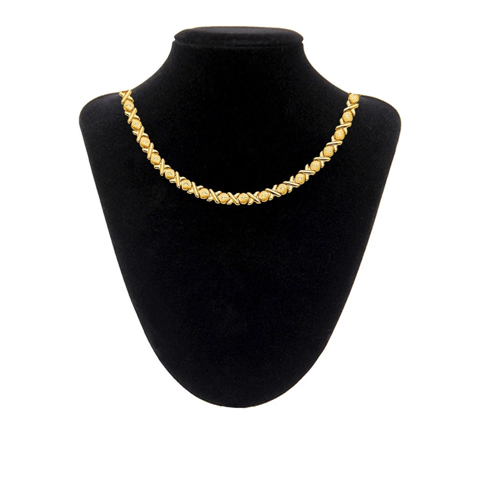 Gold necklace on a black mannequin bust against a white background available on the TX.ORO website.