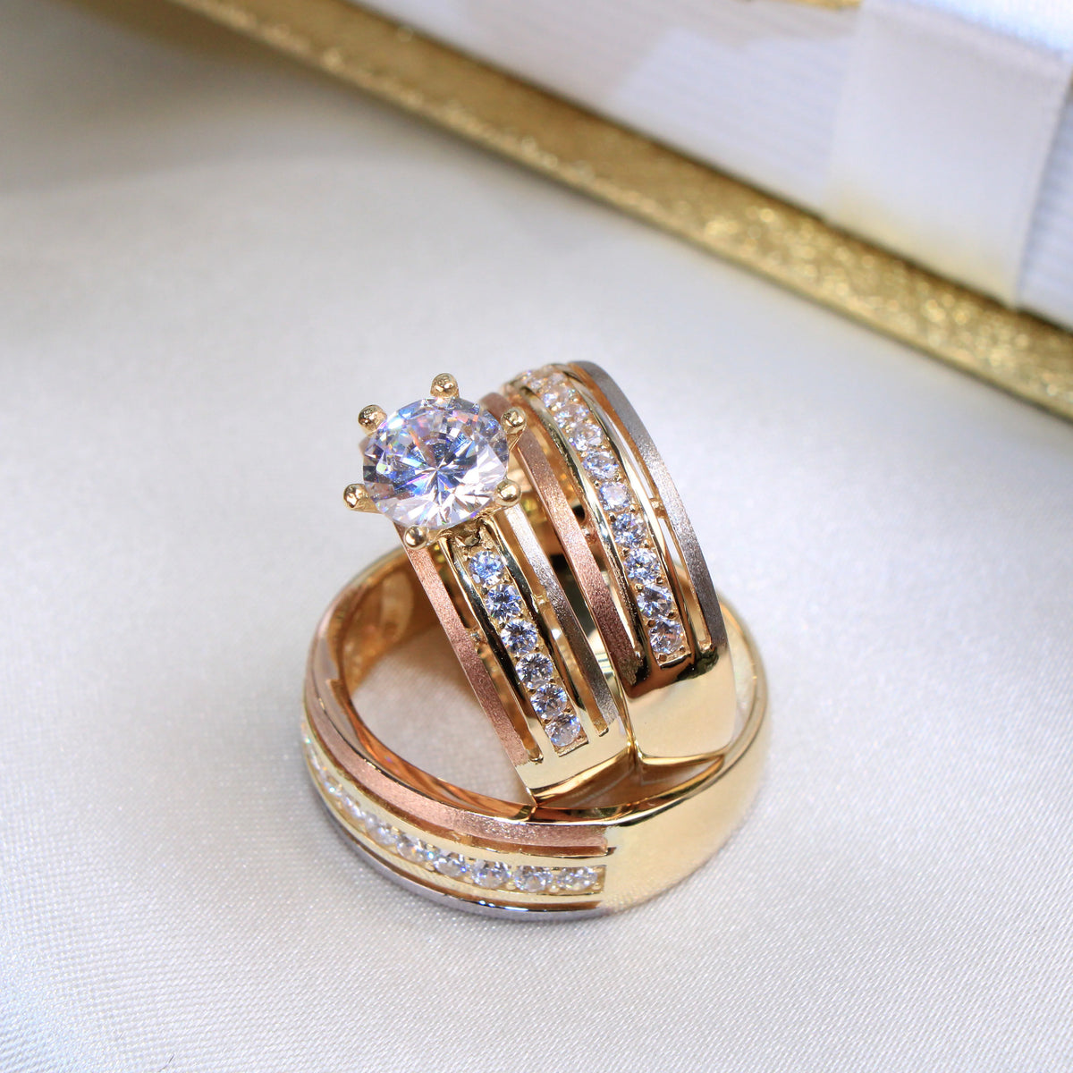 Gold ring with diamond accents on a light fabric background availabe on TX.ORO website.