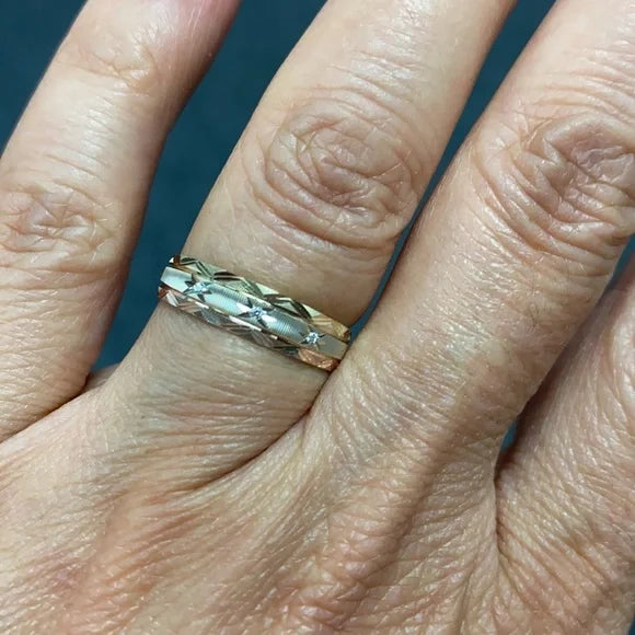 Close-up of a hand wearing a gold ring with a blue background