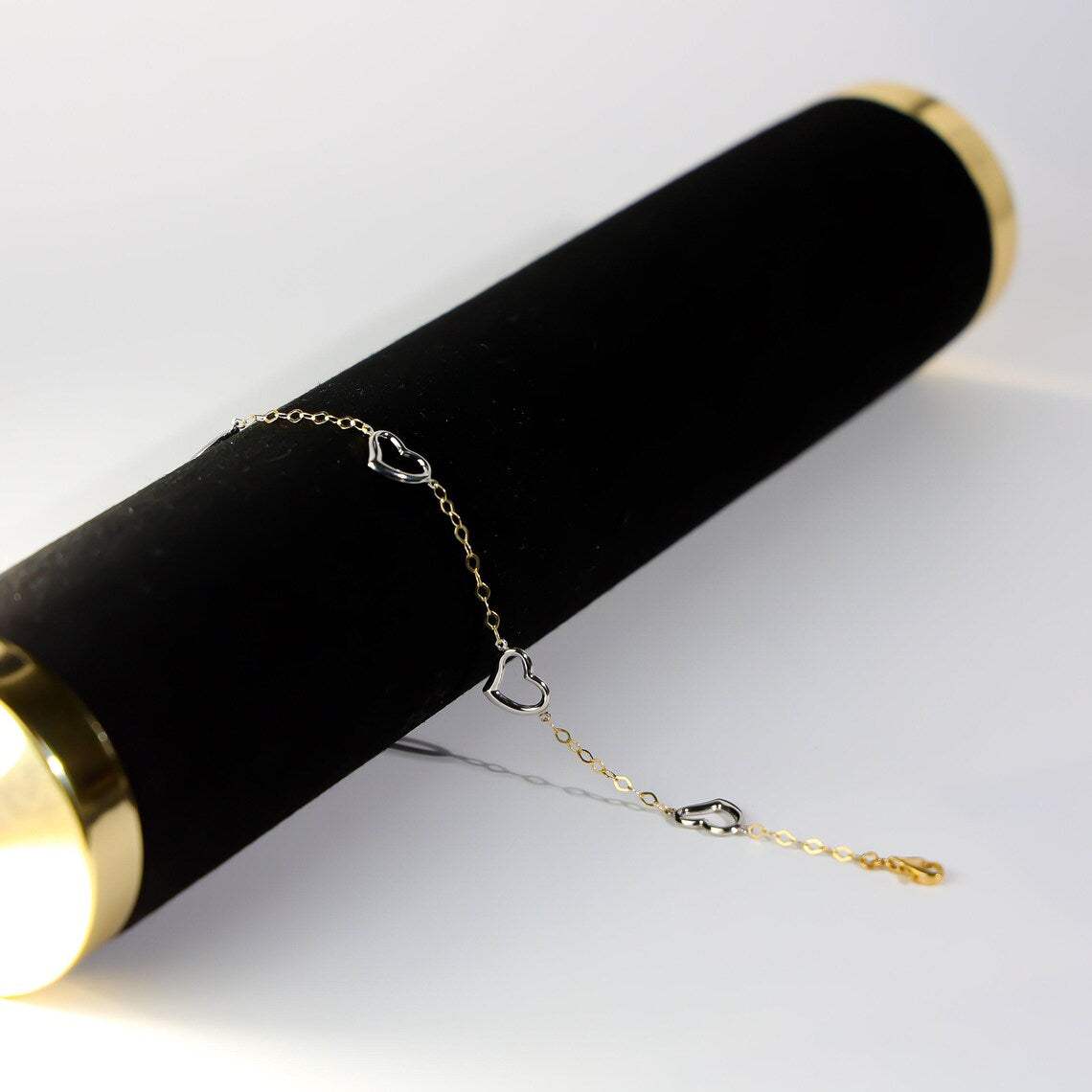 Gold bracelet on a black cylindrical stand with a white background available on the TX.ORO website.