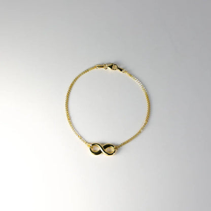 Gold bracelet with a double infinity symbol on a light gray background available on the TX.ORO website.