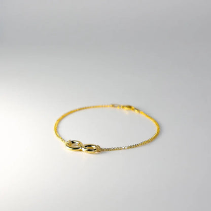 Gold bracelet with a unique clasp design on a light gray background available on the TX.ORO website.