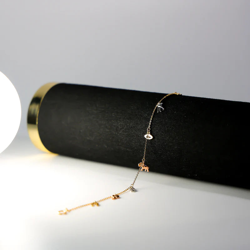 Gold bracelet on a black cylindrical stand with a gray background available on the TX.ORO website.
