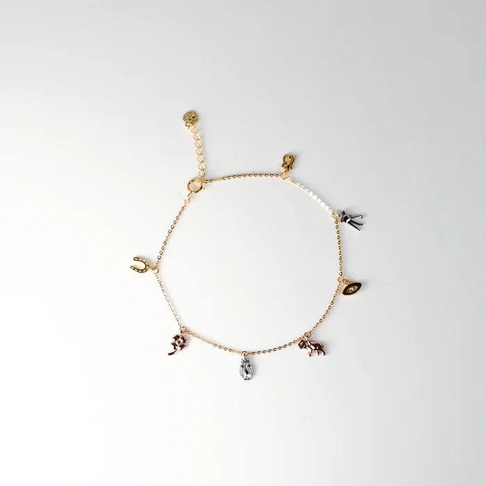 Gold bracelet with various charms on a white background available on the TX.ORO website.