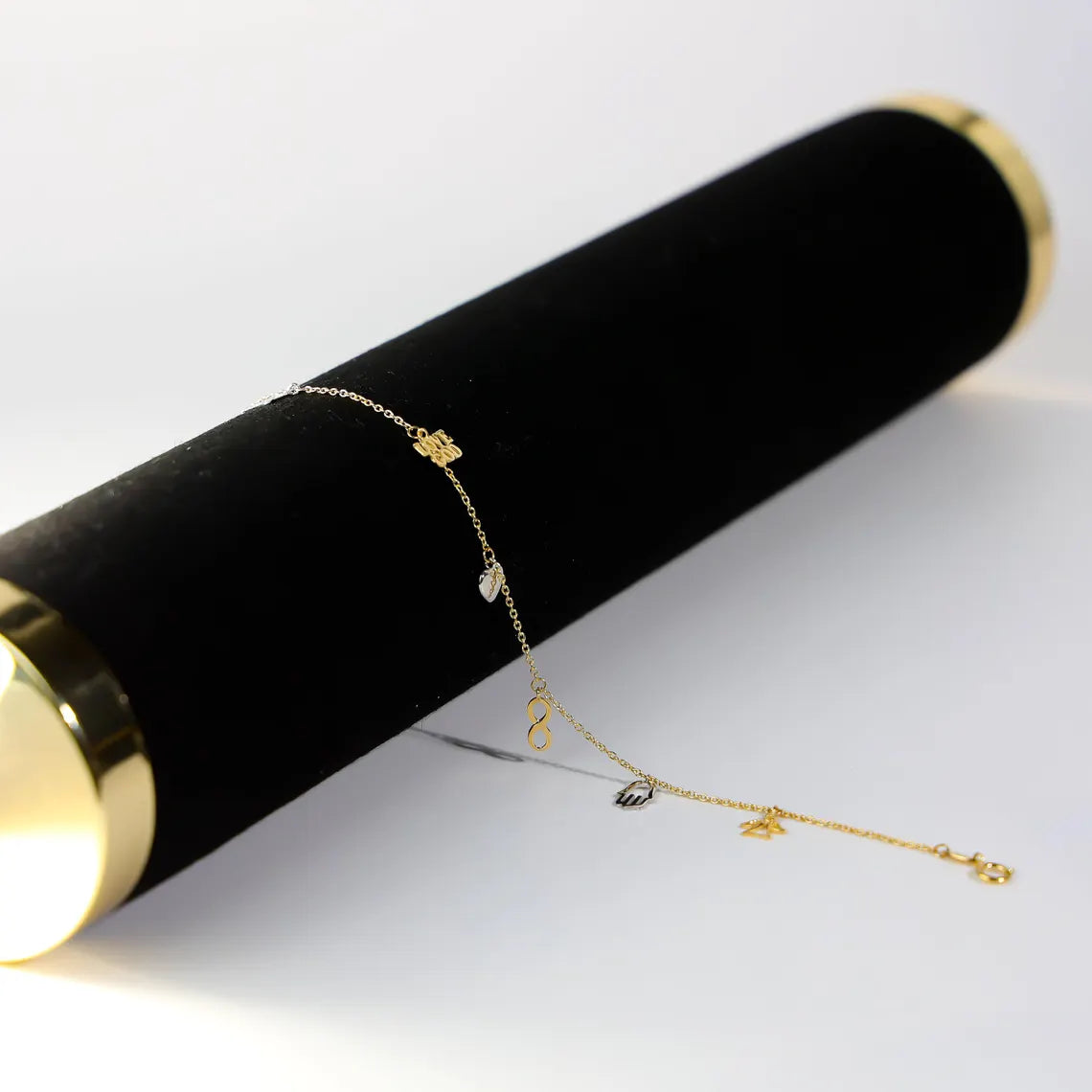 Gold bracelet on a black cylindrical stand with a white background available on the TX.ORO website.