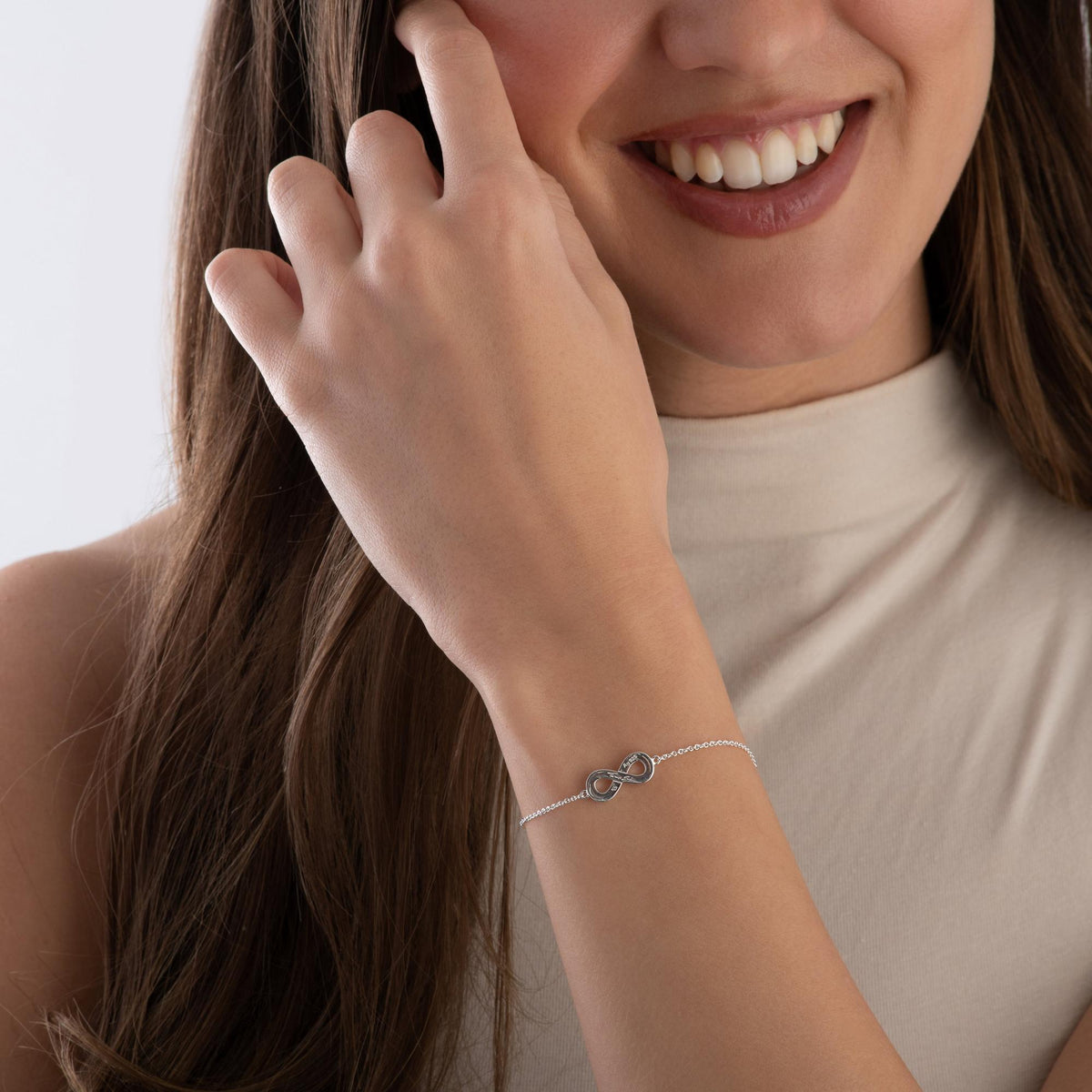 Woman wearing a silver bracelet with a plain background available on the TX.ORO website.