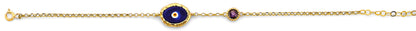 Gold bracelet with a blue evil eye charm and red gemstones on a white background