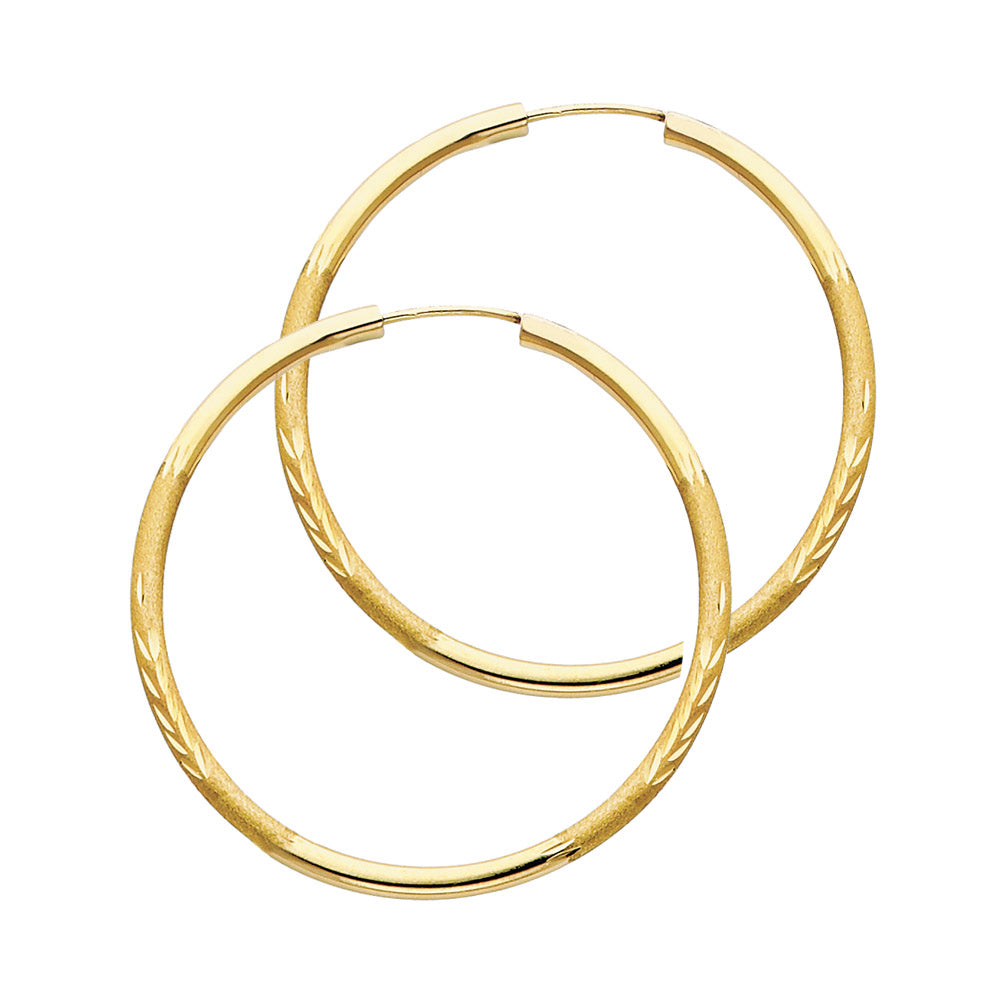 A pair of Gold hoop earrings on a white background available on the TX.ORO website.