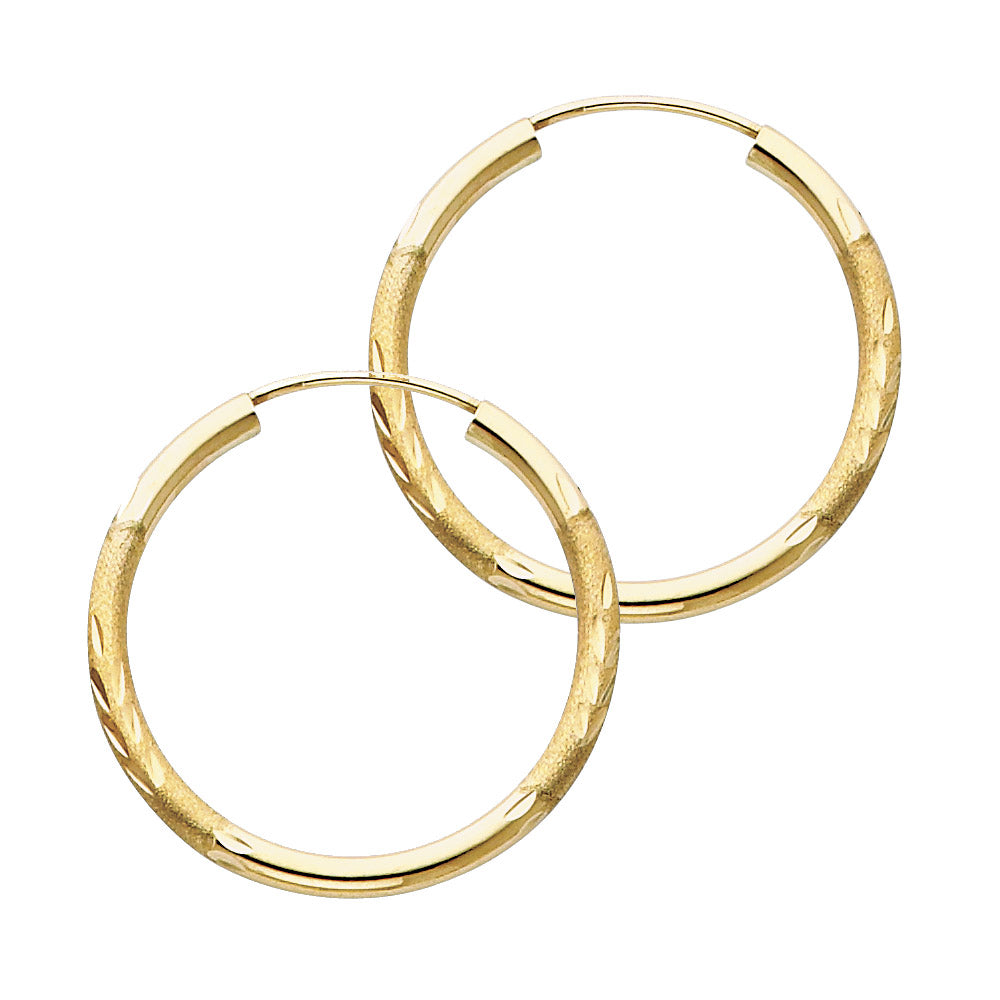A pair of Gold hoop earrings on a white background available on the TX.ORO website.
