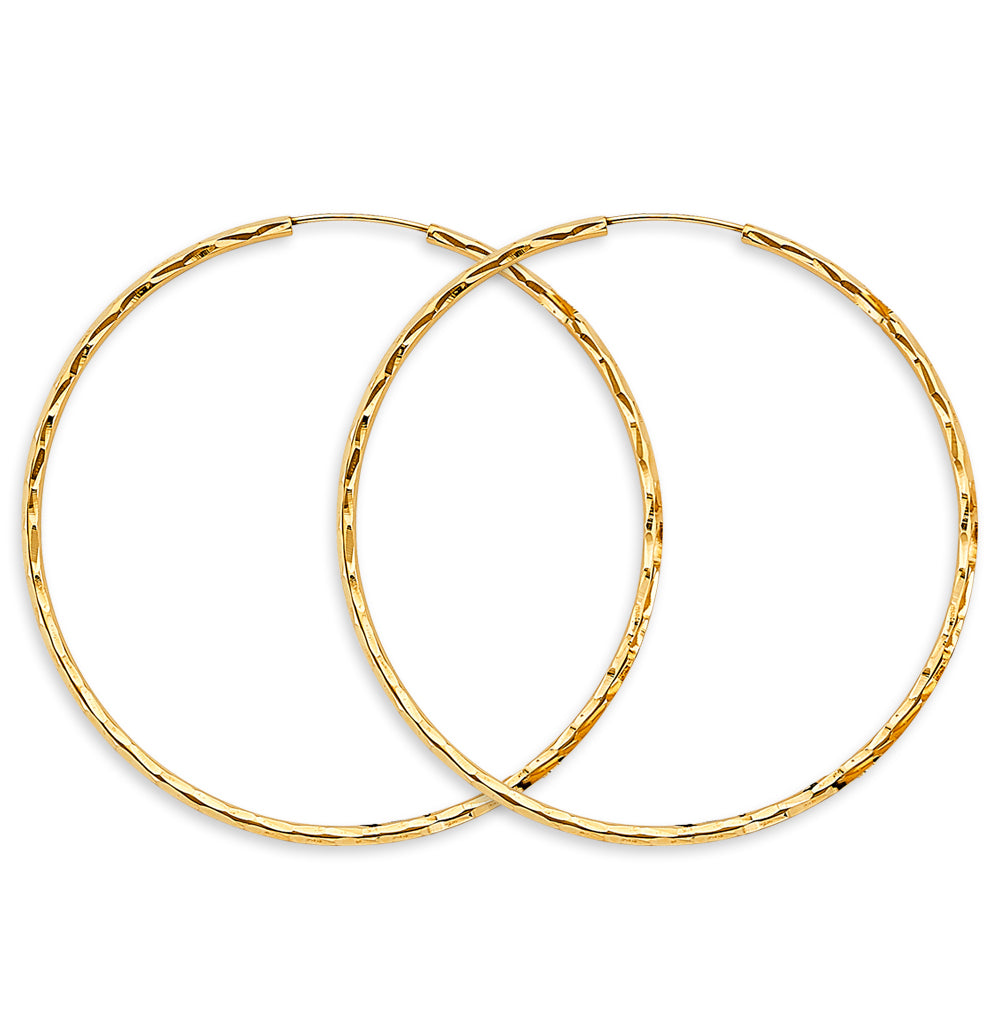 Two gold hoop earrings on a white background available on the TX.ORO website.
