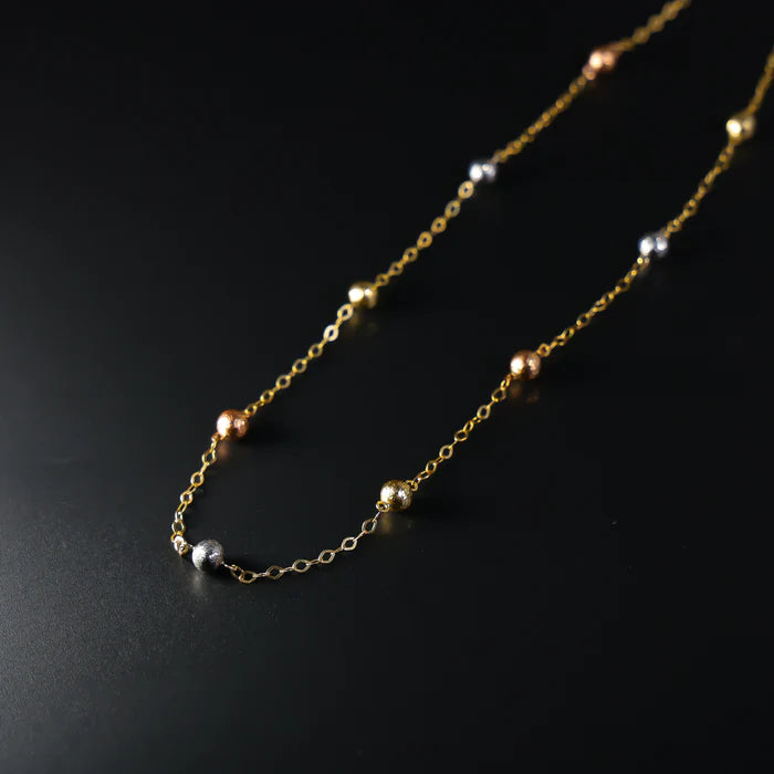 Gold chain necklace with small beads on a black background available on the TX.ORO website.