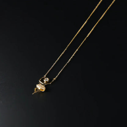 Gold necklace with a diamond pendant on a black background available on the TX.ORO website.