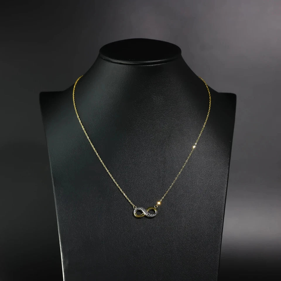 Gold necklace with a unique pendant on a black mannequin against a dark background available on the TX.ORO website.