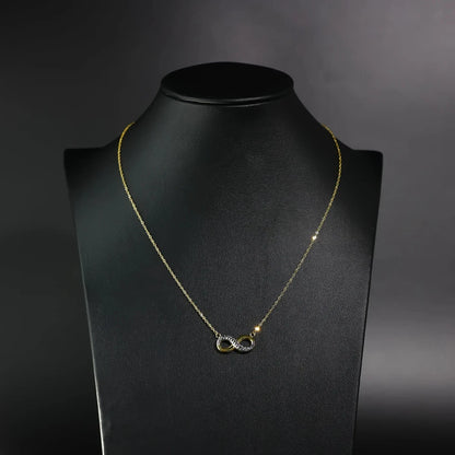Gold necklace with a unique pendant on a black mannequin against a dark background available on the TX.ORO website.