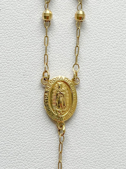 Gold necklace with a religious pendant on a white textured background availabe on TX.ORO website