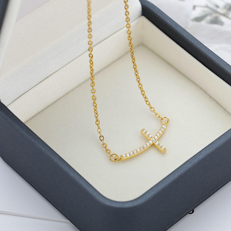 Gold necklace with a unique pendant in an open jewelry box available on the TX.ORO website.