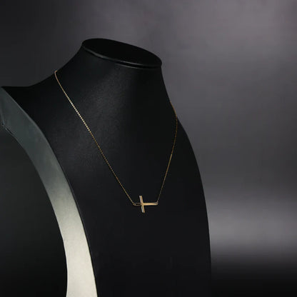 Gold necklace on a black mannequin against a dark background available on the TX.ORO website.