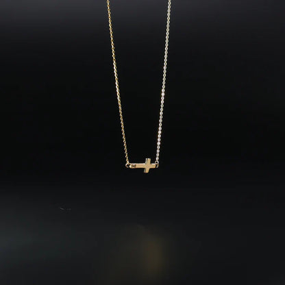 Gold necklace with a small cross pendant on a black background available on the TX.ORO website.