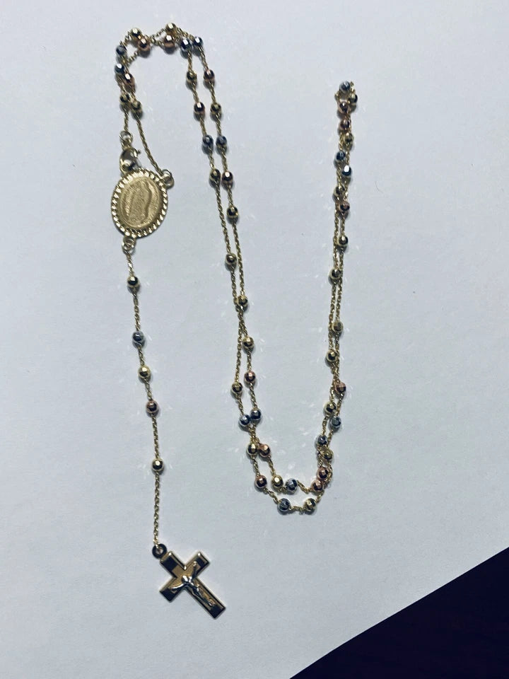 Rosary necklace with beads and cross on a light gray background availabe on TX.ORO website.
