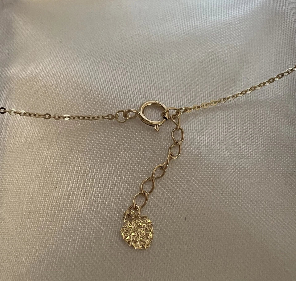 Gold necklace with a textured pendant on a light beige background available on the TX.ORO website.