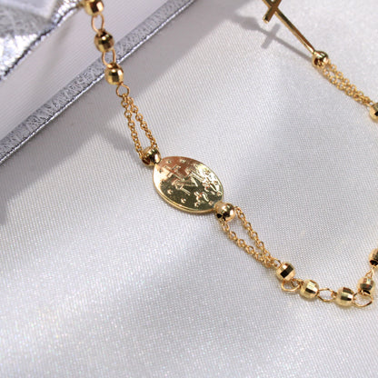 Gold bracelet with a decorative clasp on a light fabric background available on the TX.ORO website.