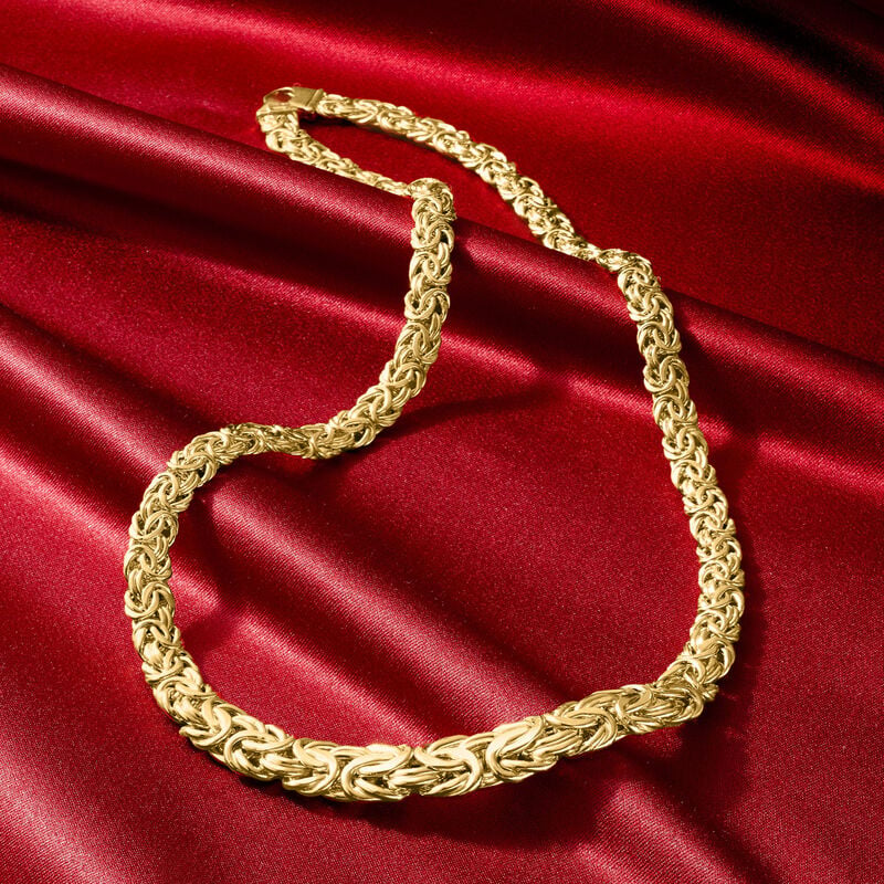 Gold chain necklace on a red satin background available on the TX.ORO website.