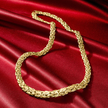 Gold chain necklace on a red satin background available on the TX.ORO website.