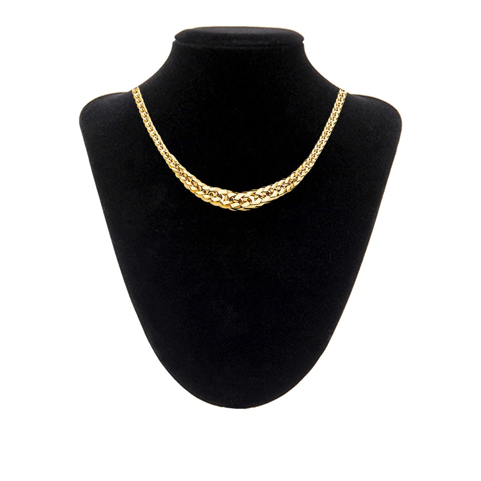 Gold chain necklace on a black mannequin bust against a white background available on the TX.ORO website.
