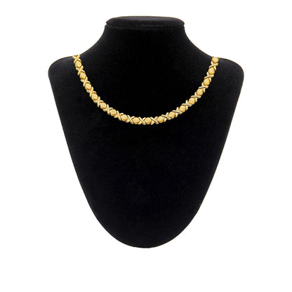 Gold necklace on a black mannequin bust against a white background available on the TX.ORO website.