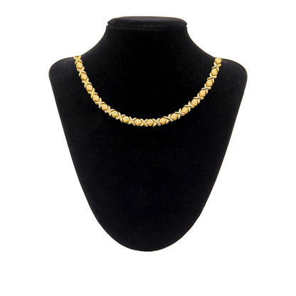Gold necklace on a black mannequin bust against a white background available on the TX.ORO website.