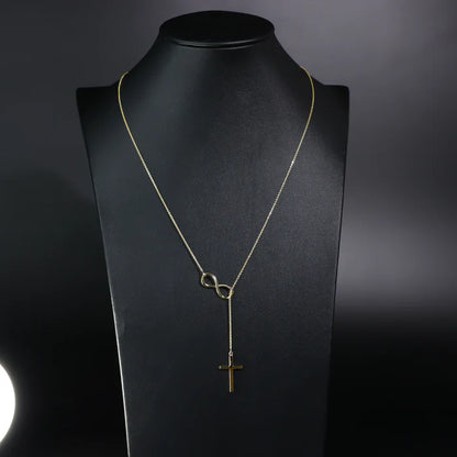 Gold necklace with infinity and cross pendants on a black mannequin bust available on the TX.ORO website.