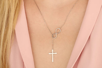 Necklace with infinity and cross pendants on a person wearing a pink jacket available on the TX.ORO website..