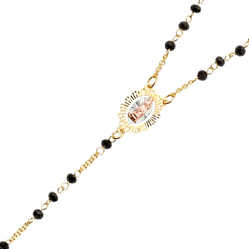 Gold necklace with black beads and a central pendant on a white background available on the TX.ORO website.