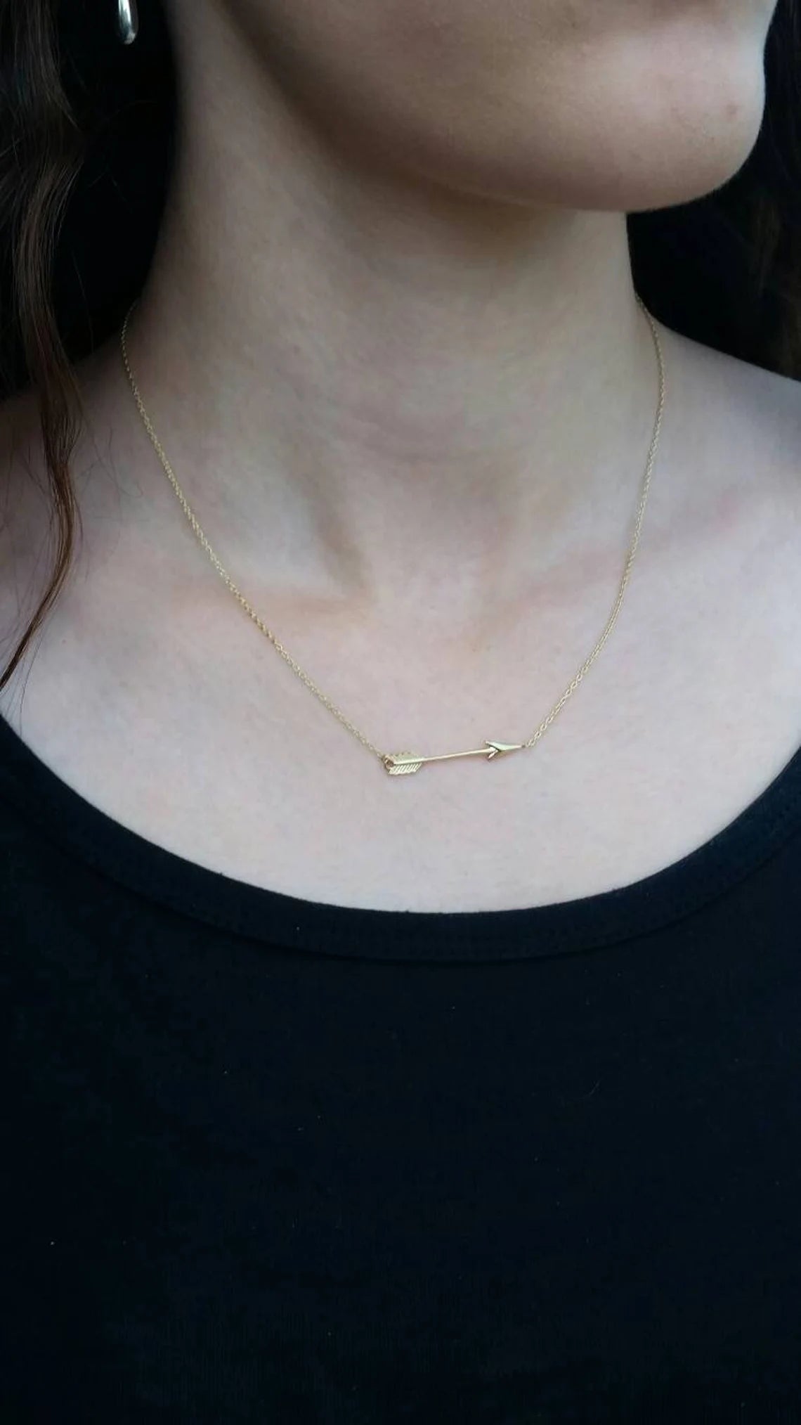 Gold necklace worn by a person against a black background available on the TX.ORO website.