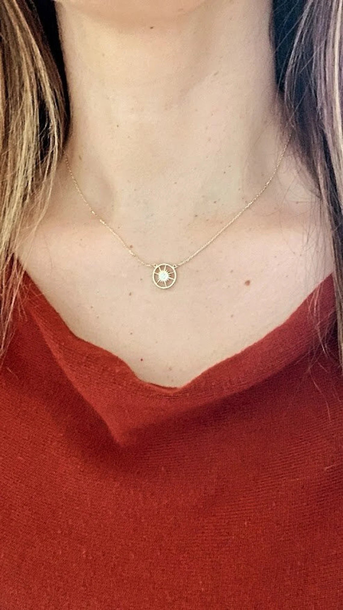 Necklace with a small round pendant worn by a person in a red top available on the TX.ORO website.
