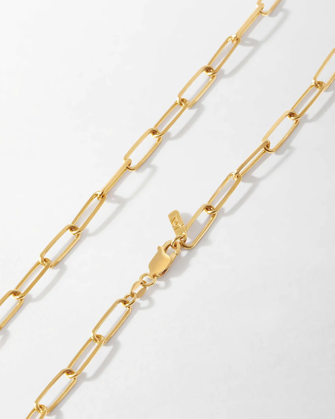 Gold chain necklace on a light gray background available on the TX.ORO website.
