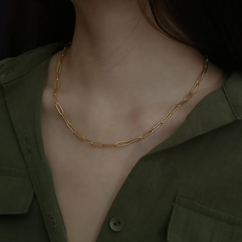 Gold chain necklace worn by a person with a dark background available on the TX.ORO website.