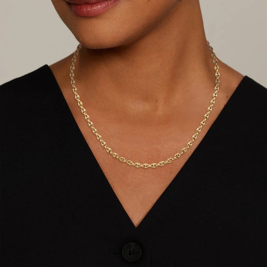 Gold chain necklace worn by a person against a neutral background available on the TX.ORO website.