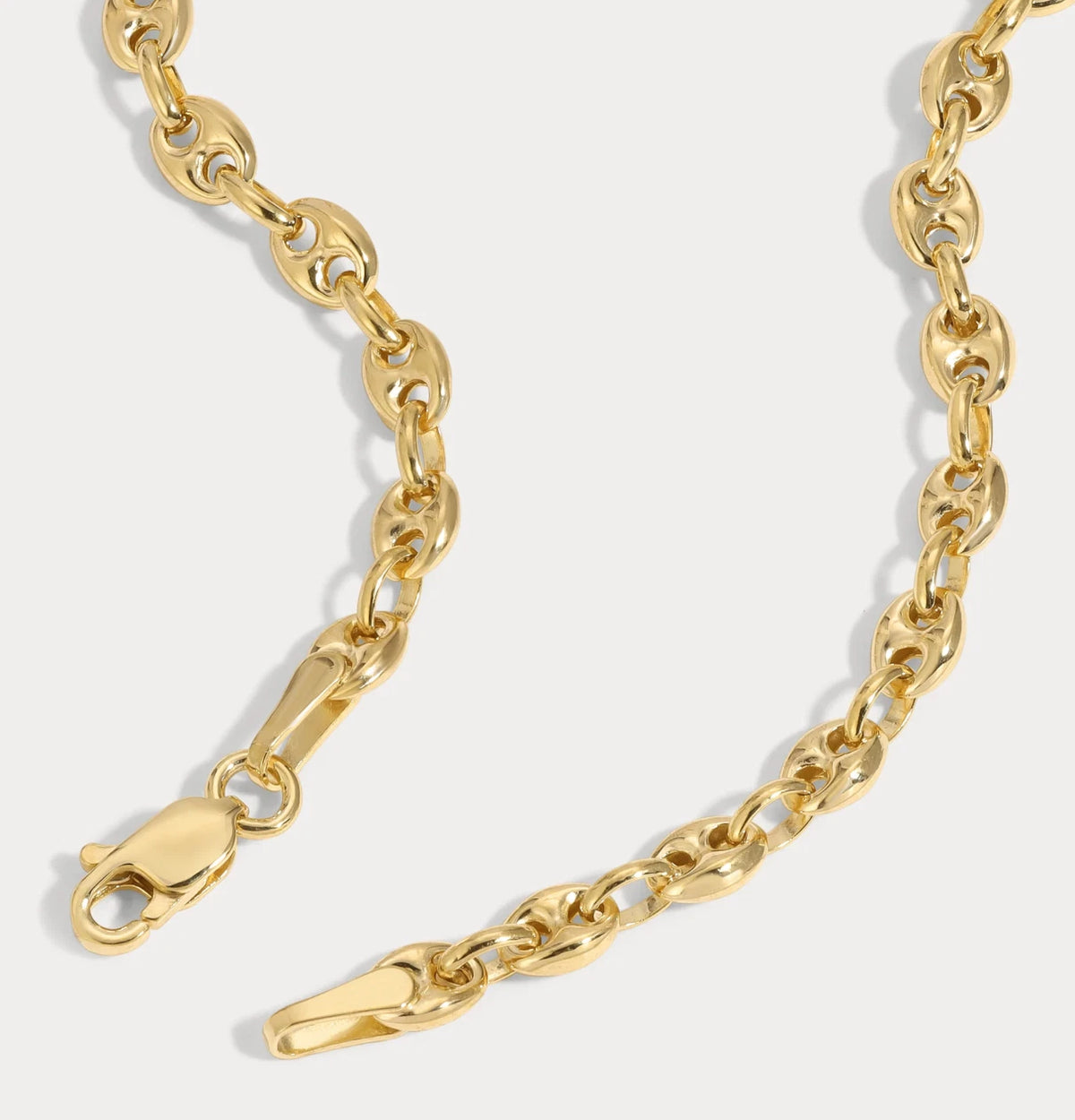 Gold chain bracelet on a light gray background available on the TX.ORO website.