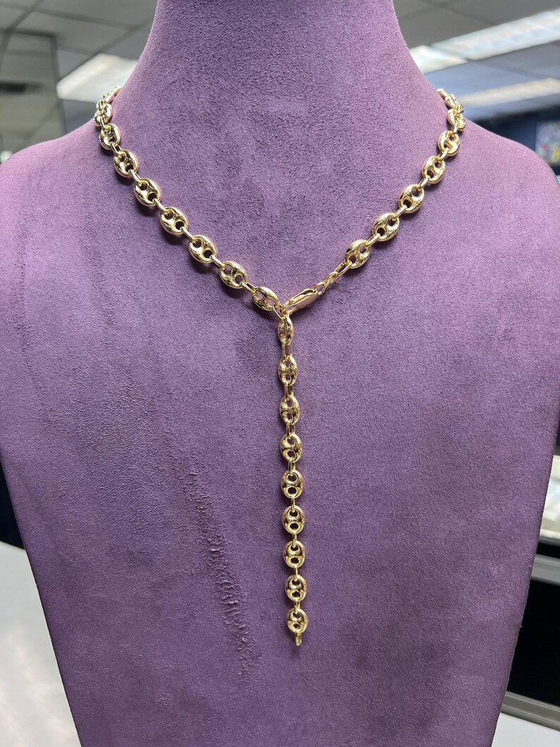 Gold chain necklace on a purple mannequin available on the TX.ORO website.