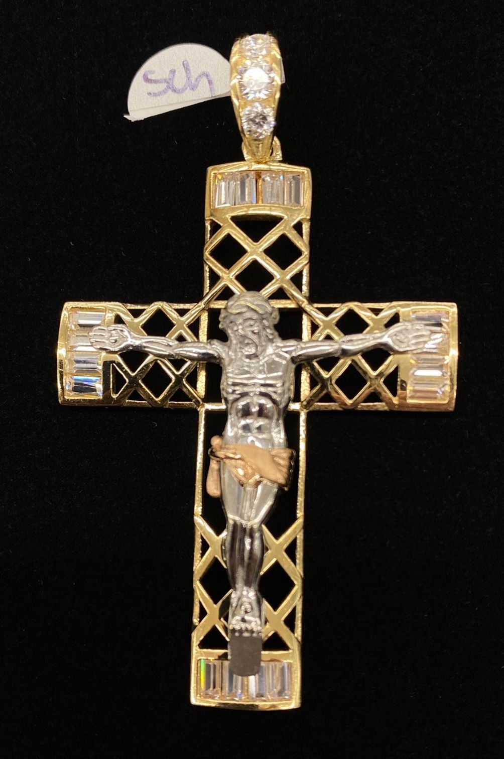 Gold and silver crucifix pendant on a black background