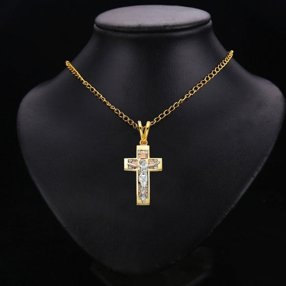 Gold cross pendant necklace on a black mannequin bust available on the TX.ORO website.