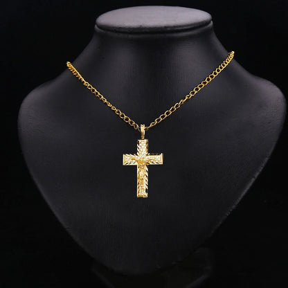 Gold cross necklace on a black mannequin bust