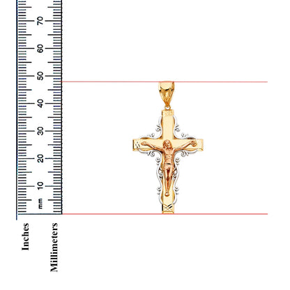 Gold crucifix pendant with ruler for scale on a white background