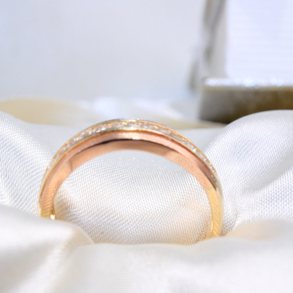 Rose gold ring with diamond accents on a white cushion availabe on TX.ORO website.