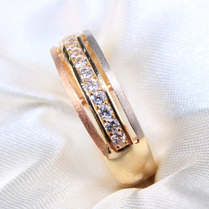Gold ring with embedded diamonds on a white fabric background availabe on TX.ORO website.