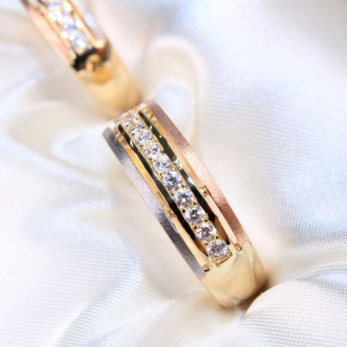 Gold ring with embedded diamonds on a white fabric background availabe on TX.ORO website.