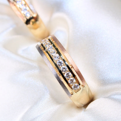 Gold ring with embedded diamonds on a white fabric background availabe on TX.ORO website.