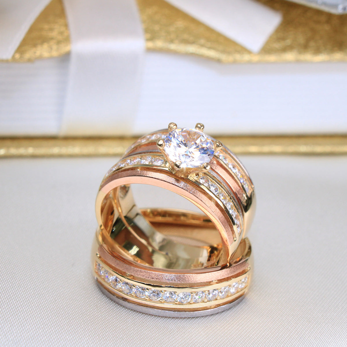 Rose gold wedding ring set on a white and gold fabric background availabe on TX.ORO website.